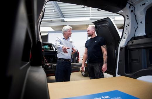Erhvervskunde og rådgiver fra Auto Group Nordvest i dialog bag i en Volkswagen e‑Transporter med åben bagdør.